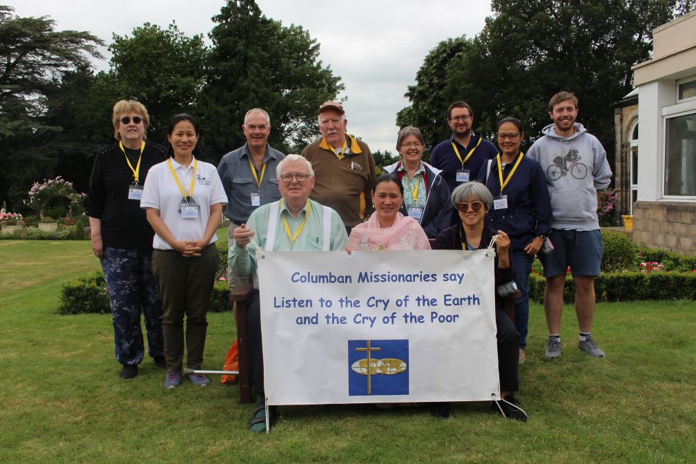 JPIC team and Lay missionaries holding banner which reads 'Listen to the cry of the earth and the cry of the poor'