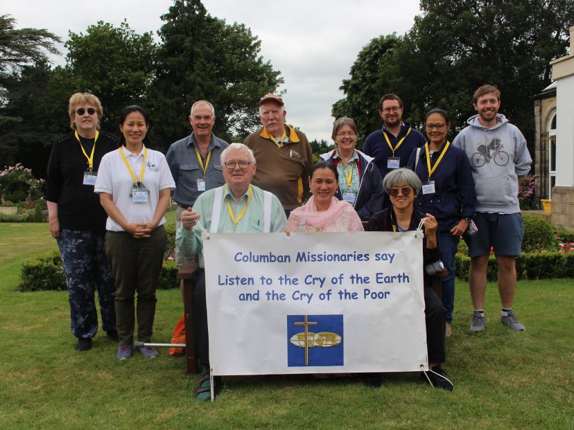 JPIC team and Lay missionaries holding banner which reads 'Listen to the cry of the earth and the cry of the poor'