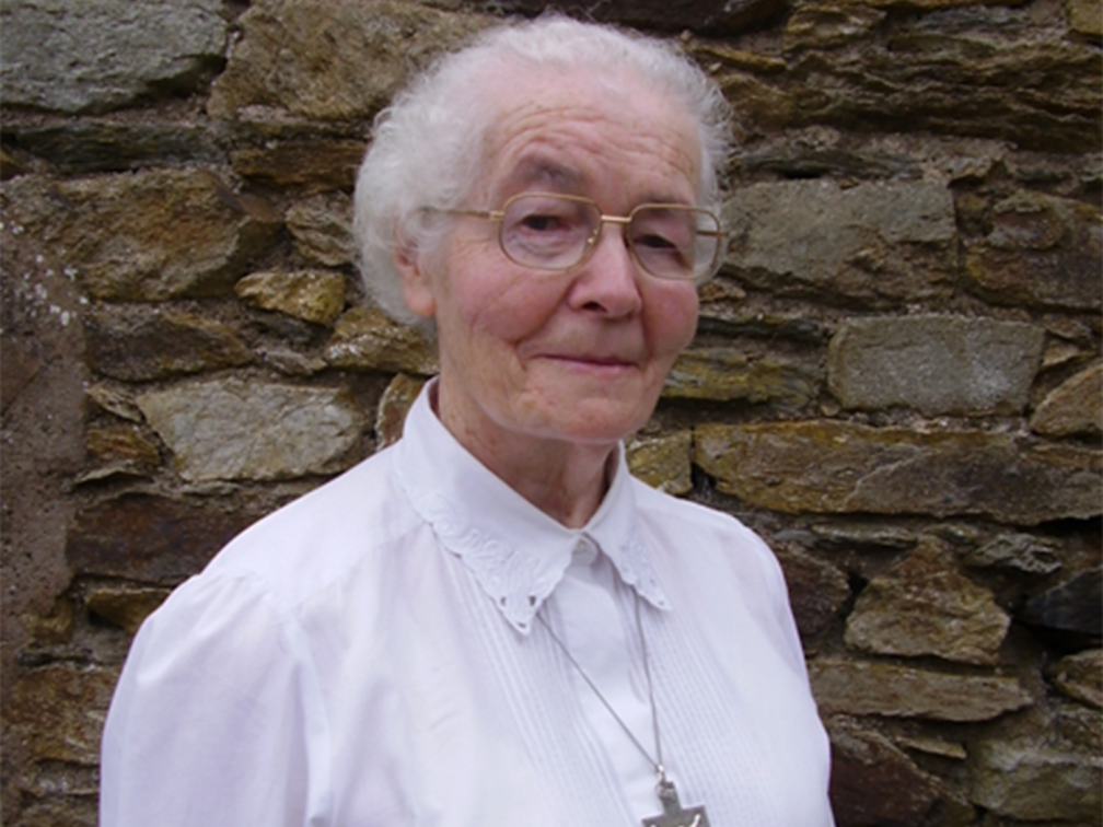 Sr Taaffe stands against a brick wall