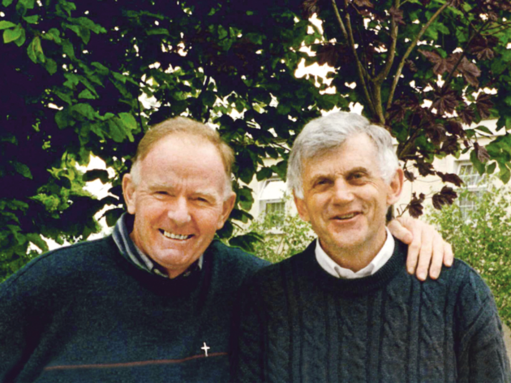 Rufus Halley and Des Hartford embrace whilst looking at camera