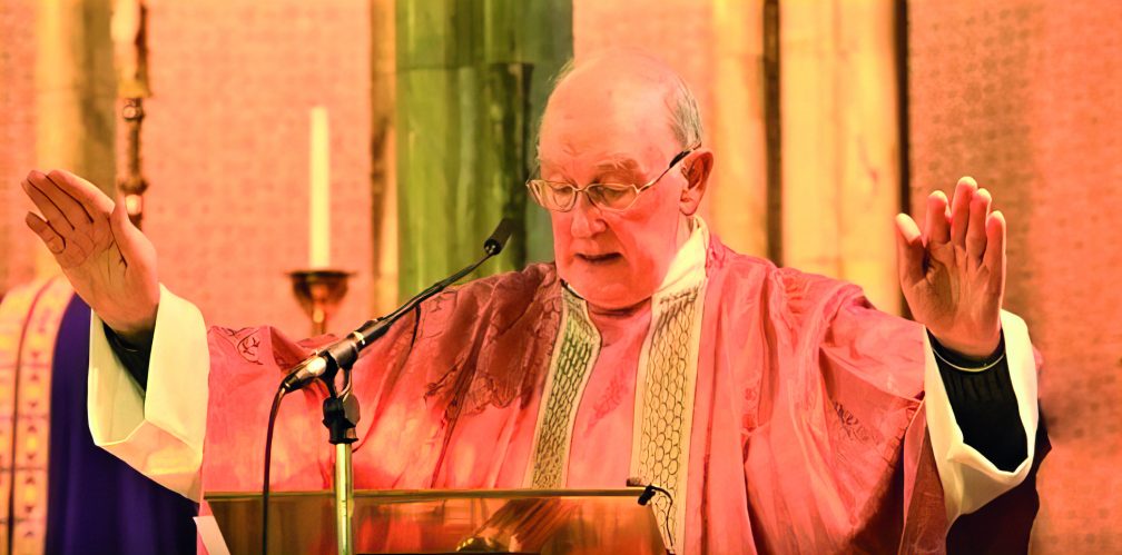 priest with hands over altar