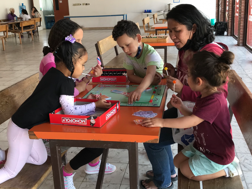 female and children st around a table and do activities