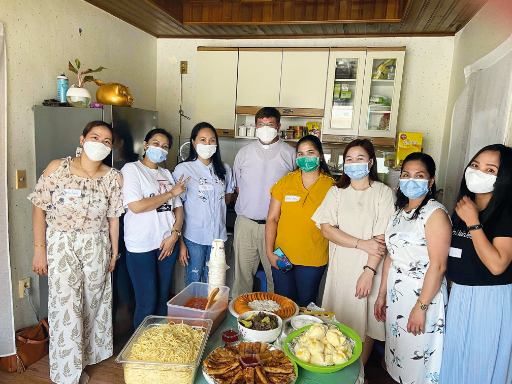 people surround a table with food