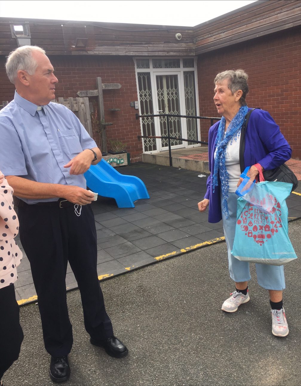 Fri John talks with a female parishioner