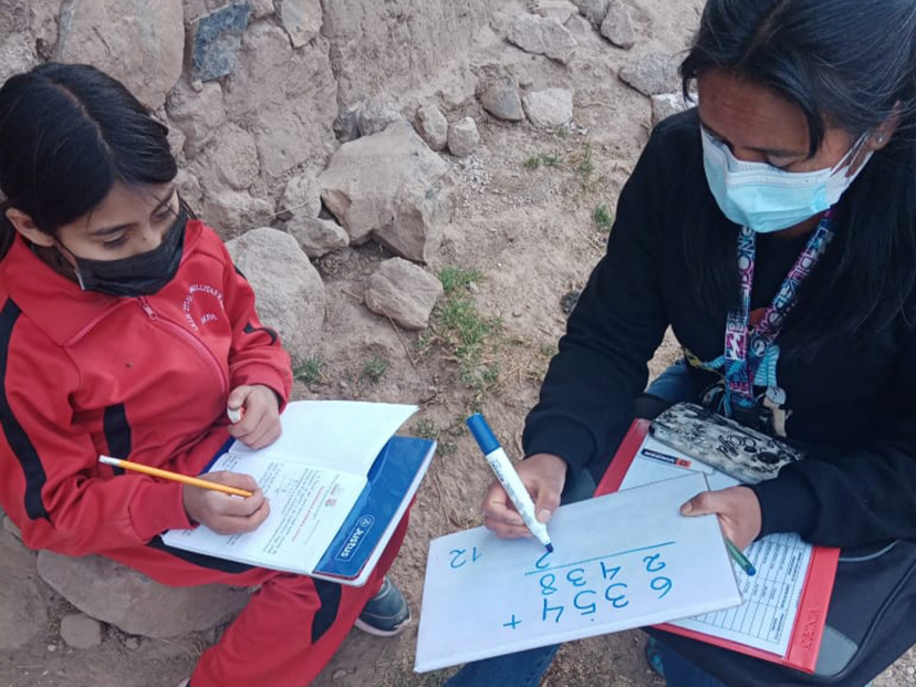 techer and student write on whiteboard with numbers