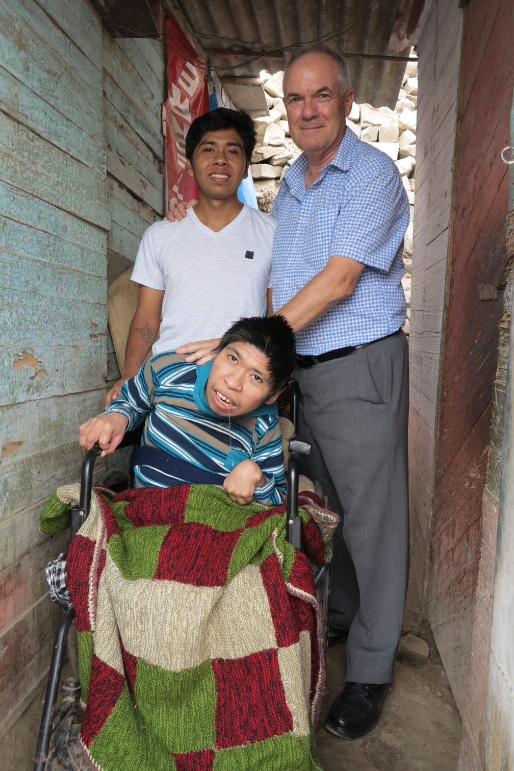 Older man with two young boys, one of whom is in a wheelchair