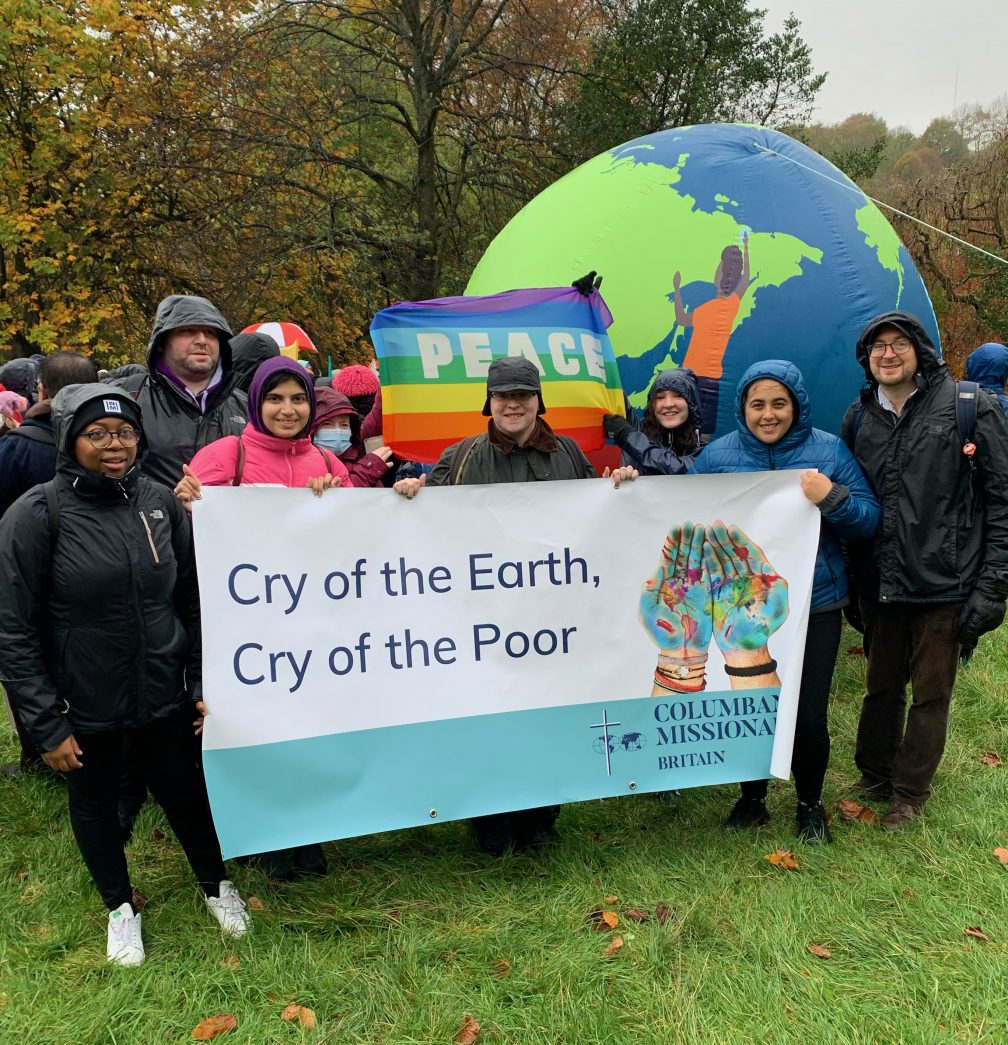 Columbans outside with a large banner