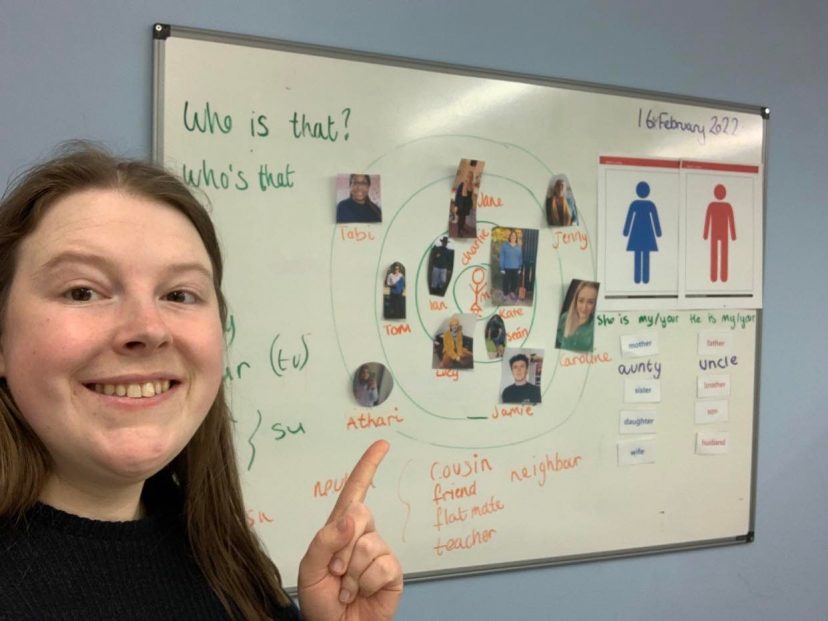 Female in front of an education board