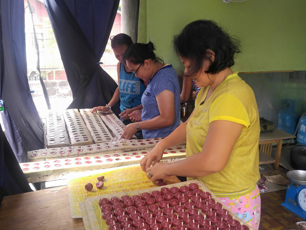 females at a table sort through candles