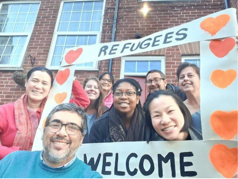 faces and hand made 'Refugees Welcome' banner