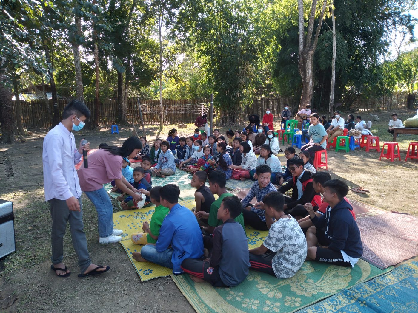 students and children sit in a circle