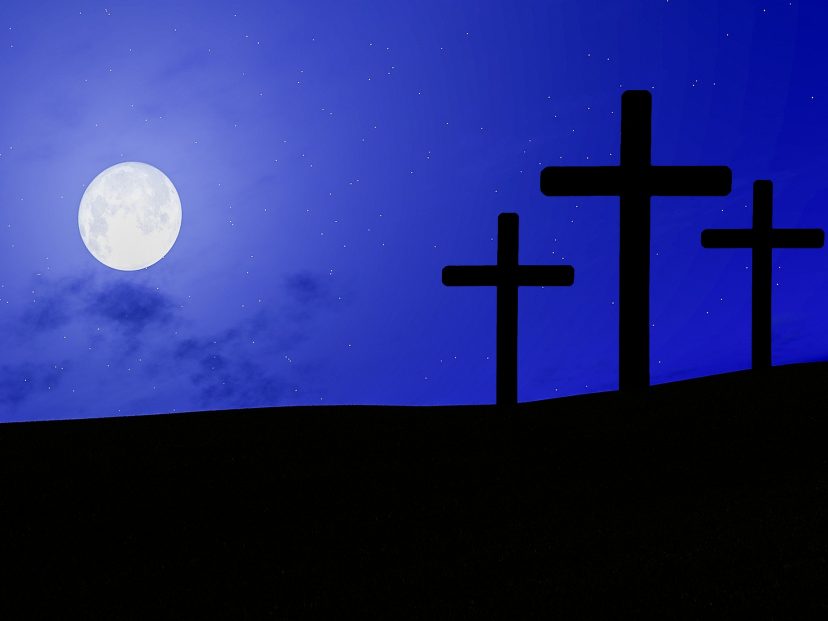 Three crosses against blue sky and moon