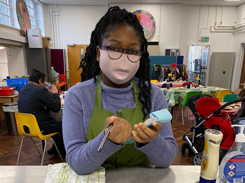 Tobi has a pen and notepad in her hands ready to take an order