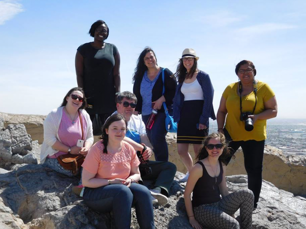 people look ta camera perched upon rocks