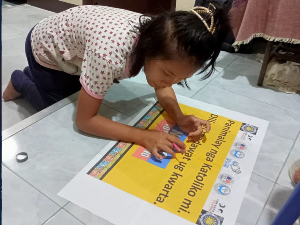 girl bent over making poster