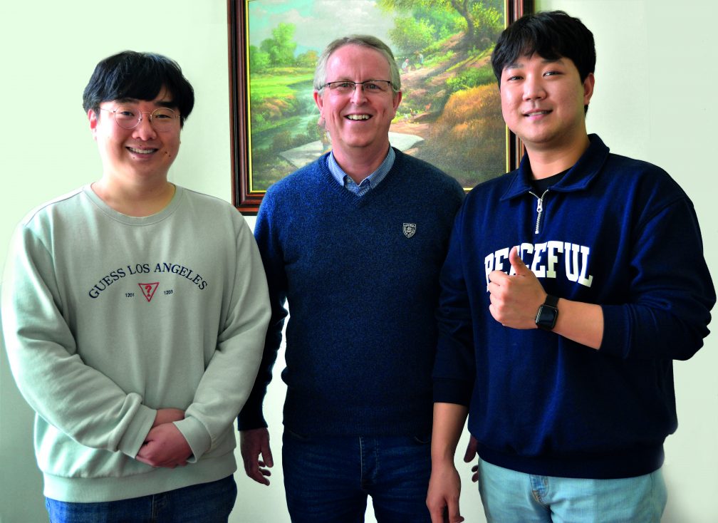 three males pose for a photograph