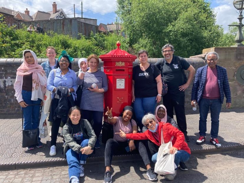 A group stand in front of a red post box at the Black Country Living Museum