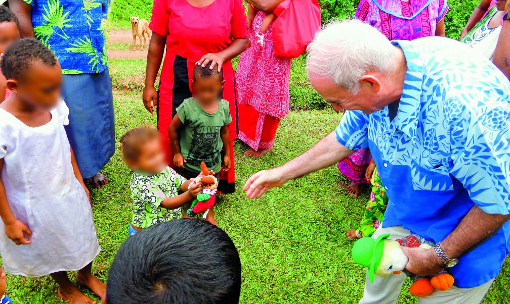 Fr Frank gives a toy to a delighted little girl for Christmas at Tamaquto.