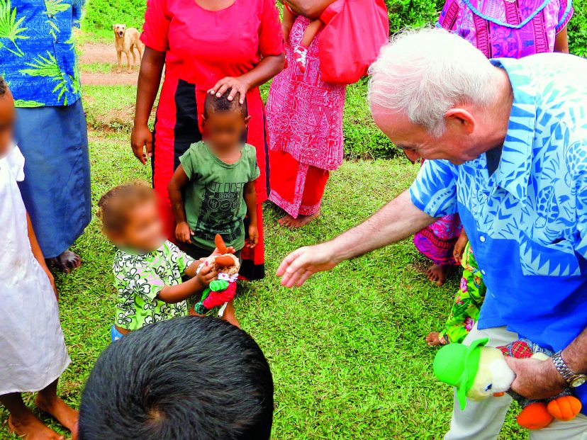 Fr Frank gives a toy to a delighted little girl for Christmas at Tamaquto.