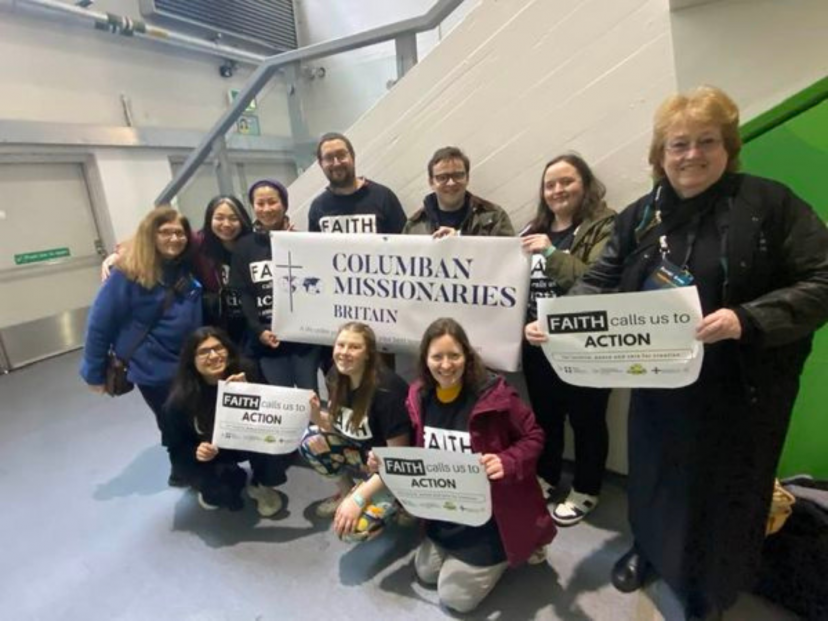 Columbans and young people hold banners at Flame