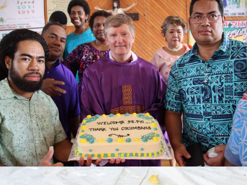 Fr Peter O'Neill with parishioners and a cake