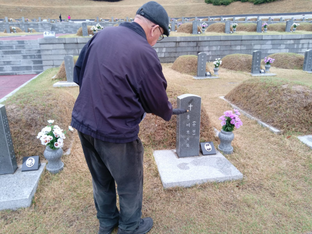Michael at the grave of a Catholic victim of the Gwangju Massacre