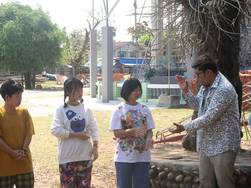 Teacher Zau Seng Awng participating in a group activity with students.