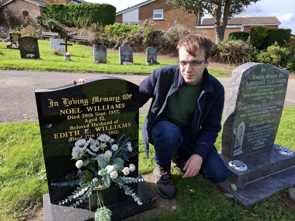 Adam beside the grave of his great-grandparents in Holywell Cemetery