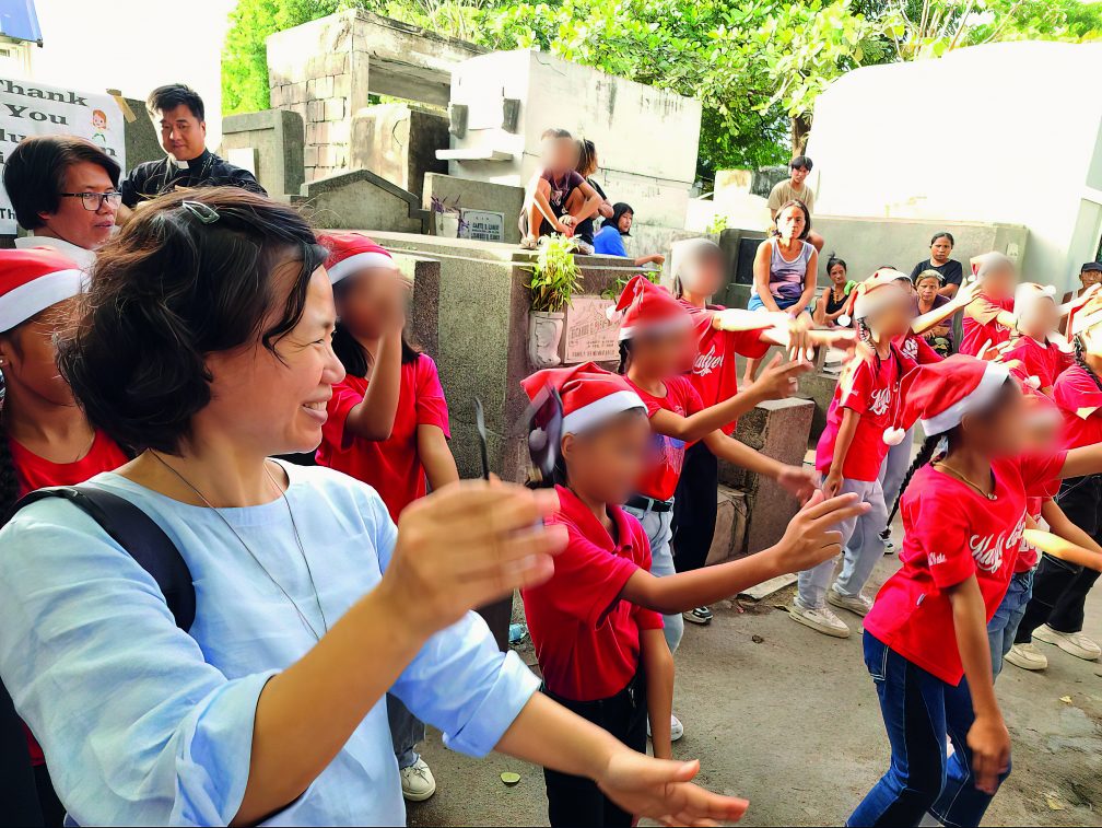Sr. Hasuk enjoying some Christmas carols with children living in Pasay City Cemetery in Manila. Photo: Sr. Hasuk Shin