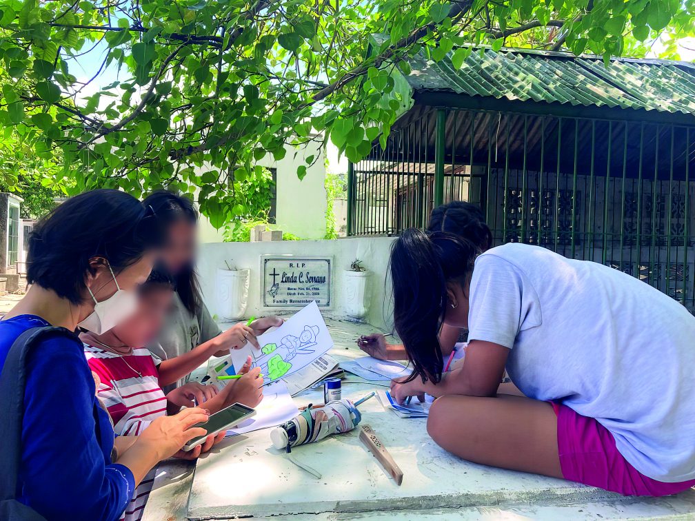 Children doing schoolwork on a tomb with the help of Sr Hasuk. Photo: Sr. Hasuk Shin.