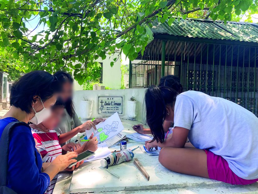 Children doing schoolwork on a tomb with the help of Sr Hasuk. Photo: Sr. Hasuk Shin.