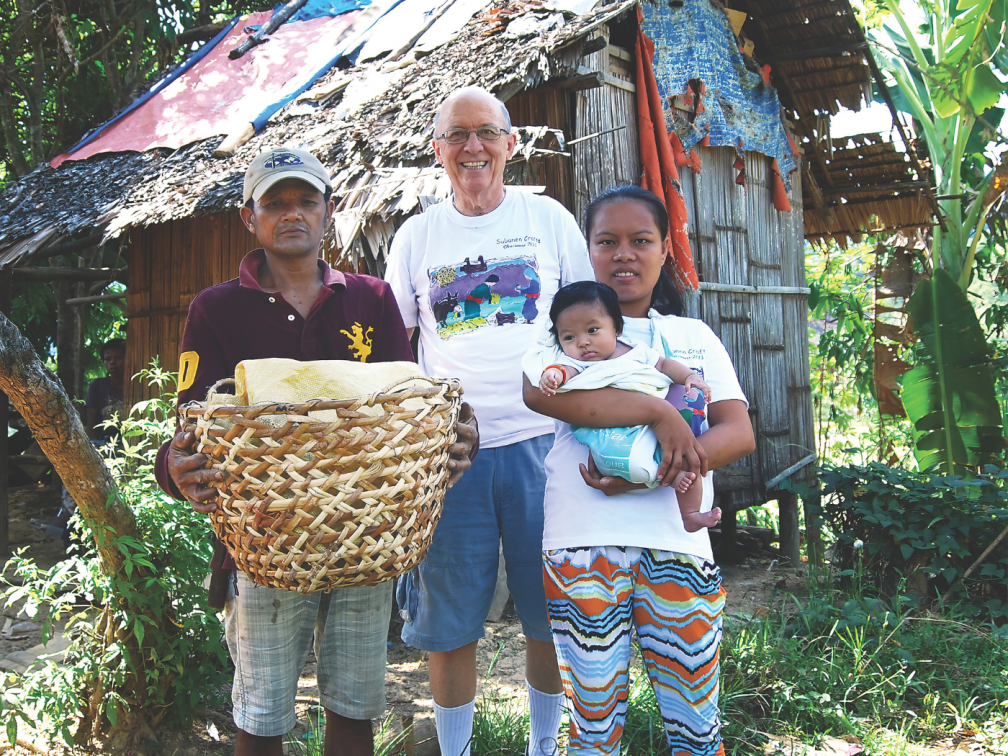 Fr. Vincent Busch with a Subanen couple and their child outside their home, which like baskets, they make from forest materials