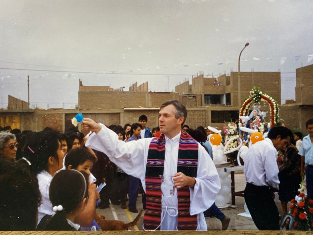 Fr. John Boles blessing the people after an outside Mass in a shanty town near Lima, Per in 1998.