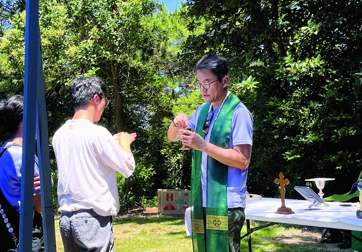 In the Garden of Grace Columban Fr Joseph Yang, director of the St Isidore Retreat Centre, distributes Communion.