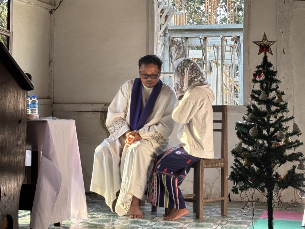 Hearing confessions before the Christmas Eve Mass in one of the villages of Nawngching Parish, Myitkyina, Kachin State