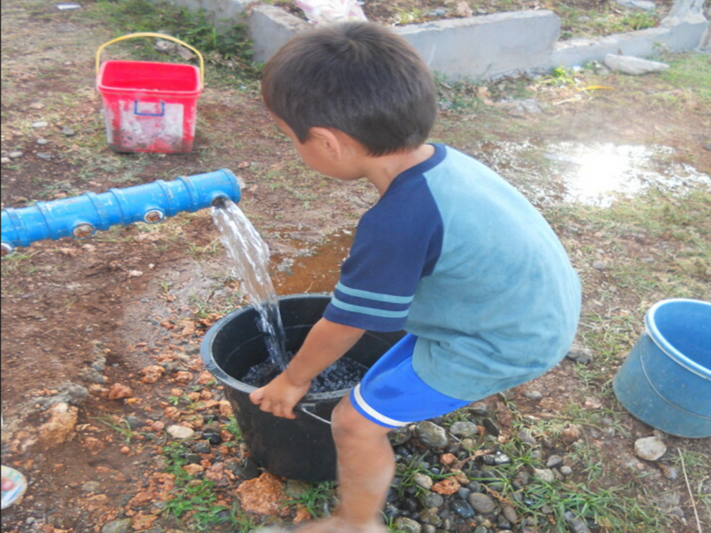 A young child collects water from a tap