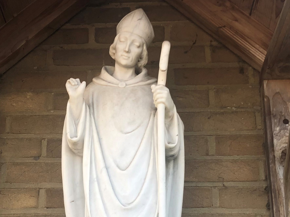 A statue of St. Hugh of Lincoln, with his swan-friend by his side, outside the church dedicated to his memory in Knaphill, Woking