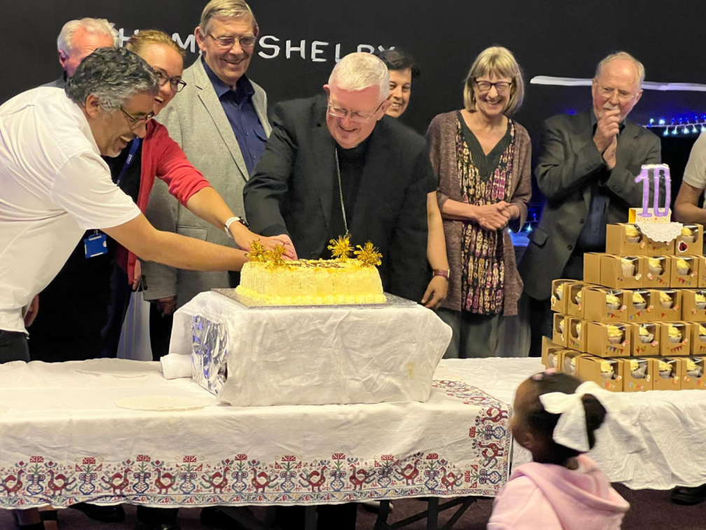 Representative of the Fatima House partnership cutting the celebratory cake