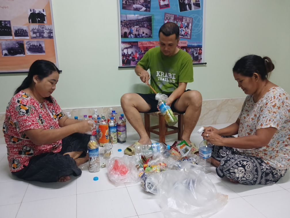 Columban Lay Missionary Michael Javier and friends fill bottles with plastic waste to create bricks to use in the garden of the Columbn central house