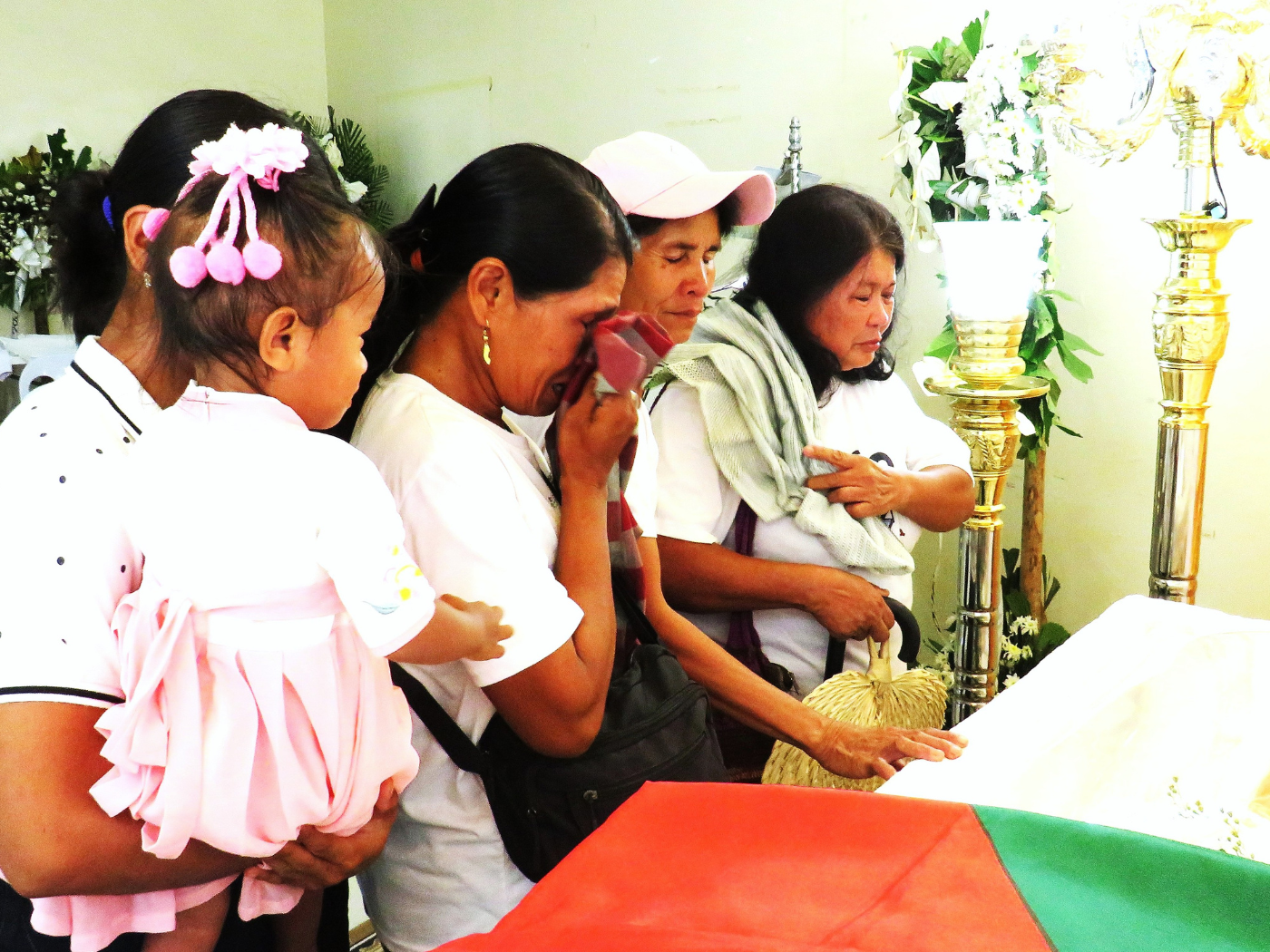 Indigenous armers touching Fr. Brian's coffin