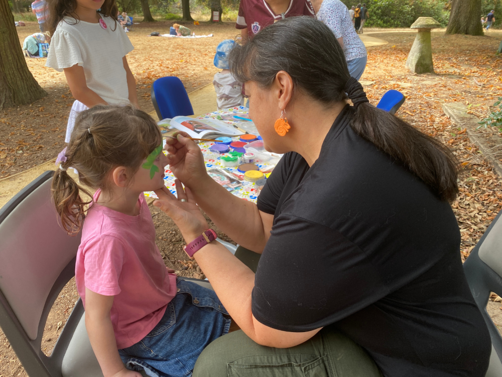 Lay missionary Nathalie Marytsch paints the face of a child during the Summer Open Day